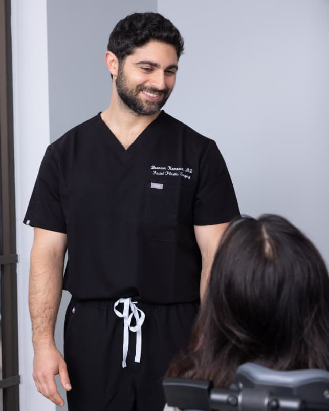 Dr. Kamrava in scrubs speaking with a patient