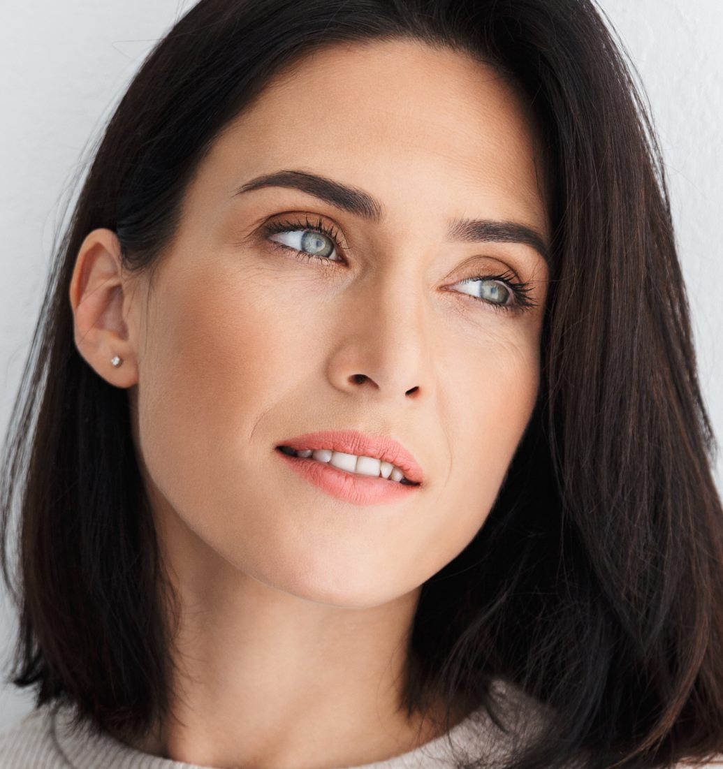 Woman with dark shoulder-length hair shown in a close-up portrait looking to the side